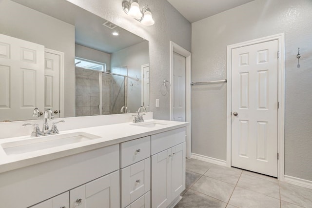 bathroom with double vanity, a shower stall, visible vents, and a sink