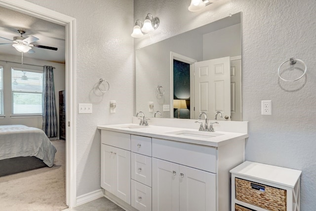 full bath featuring a textured wall, a sink, and ensuite bathroom