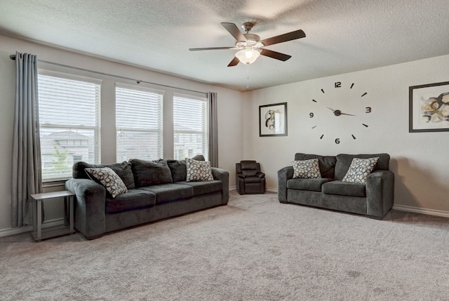 carpeted living area featuring a textured ceiling, a ceiling fan, and baseboards