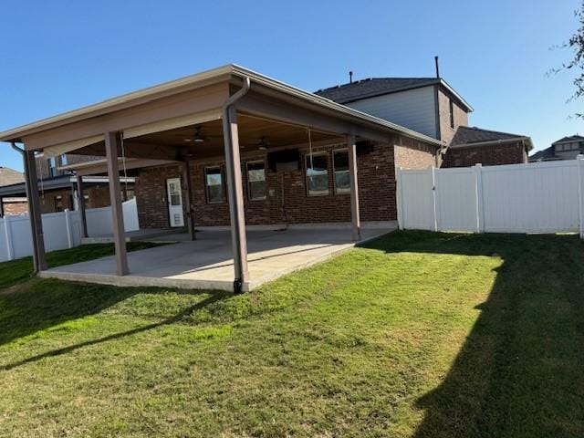 back of property featuring a yard, a fenced backyard, a ceiling fan, and a patio