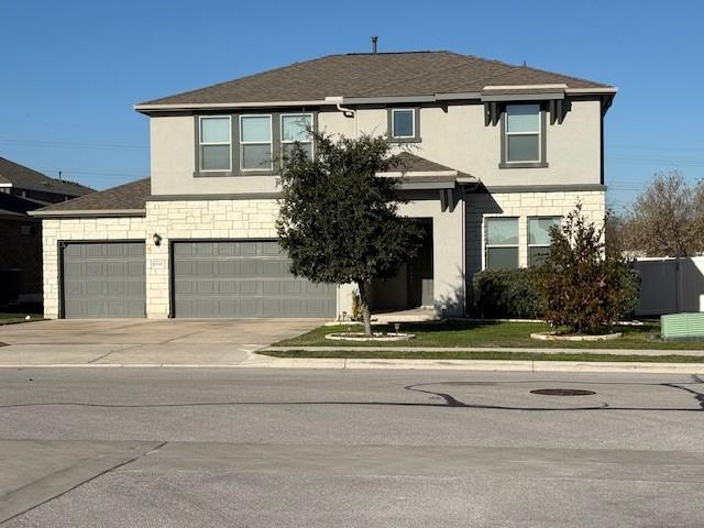 traditional-style home featuring concrete driveway, roof with shingles, and stucco siding