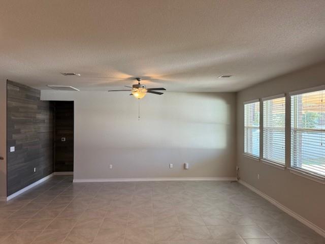 empty room with a textured ceiling and ceiling fan