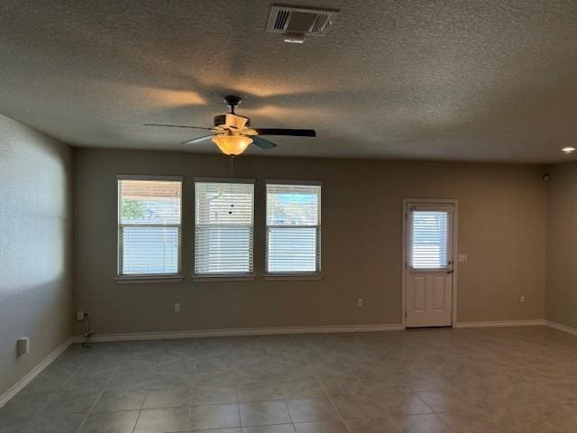 unfurnished room featuring a ceiling fan, baseboards, visible vents, and a wealth of natural light