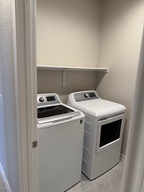 laundry area featuring light tile patterned floors, laundry area, and separate washer and dryer