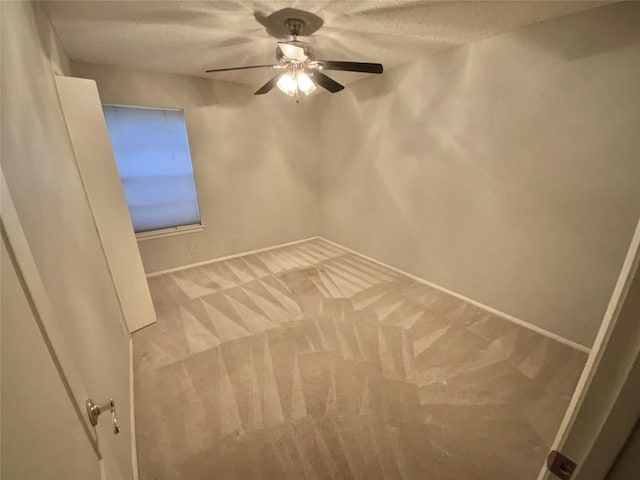 carpeted spare room with a textured ceiling and ceiling fan