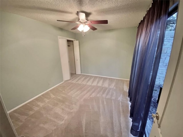 carpeted spare room with ceiling fan and a textured ceiling