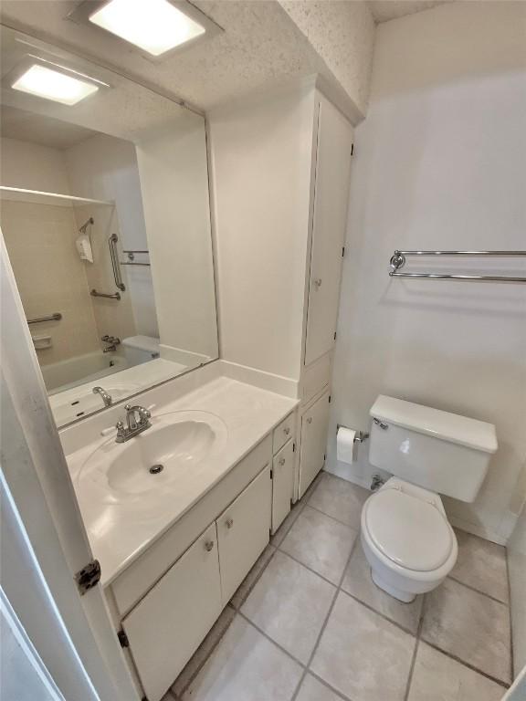 full bathroom featuring bathtub / shower combination, tile patterned floors, vanity, and toilet