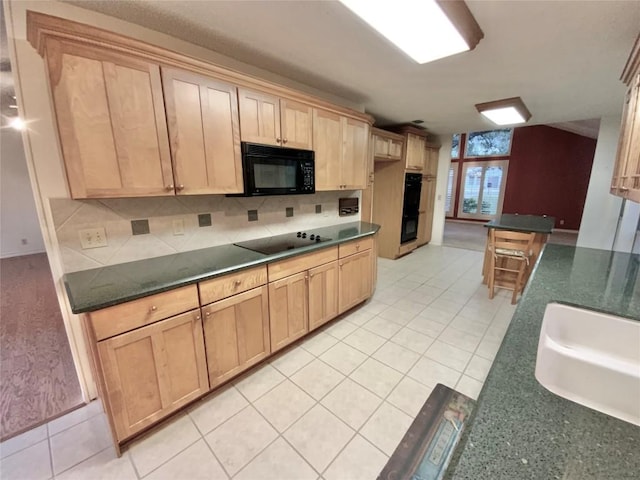 kitchen featuring light tile patterned floors, light brown cabinets, and black appliances