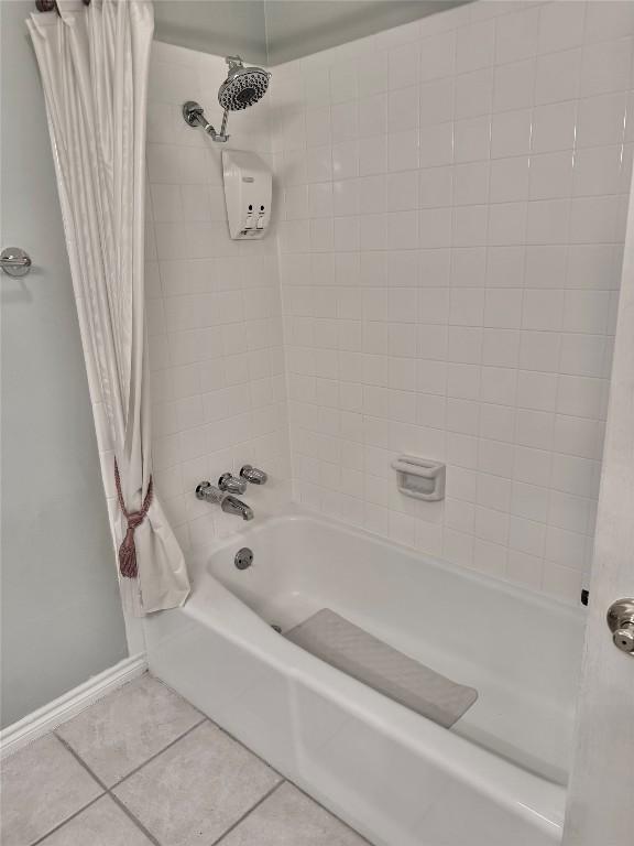 bathroom featuring shower / bath combo, baseboards, and tile patterned flooring