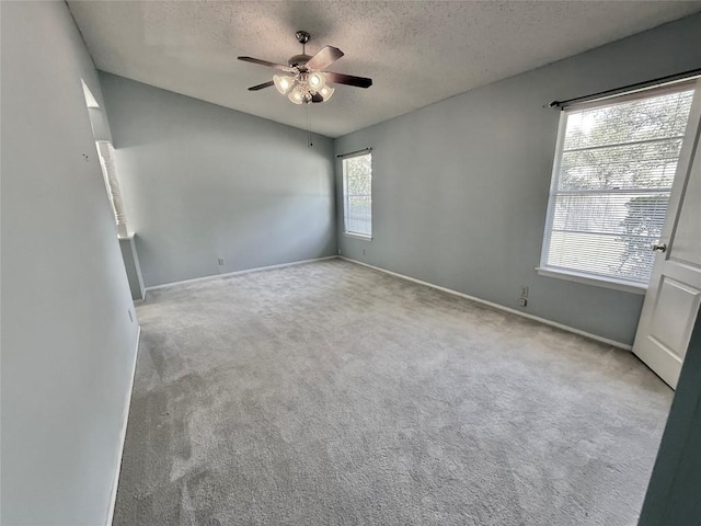 unfurnished room with a ceiling fan, baseboards, a textured ceiling, and carpet floors