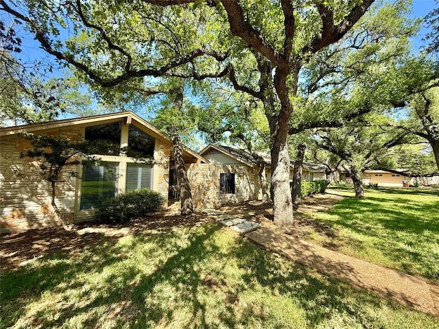 exterior space featuring stone siding and a front lawn