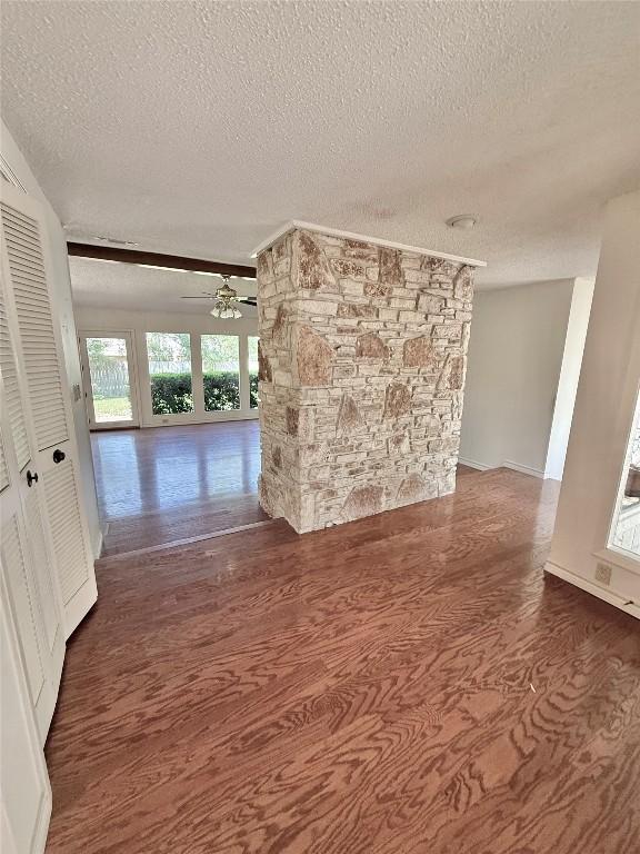 spare room with wood finished floors, a textured ceiling, and a ceiling fan