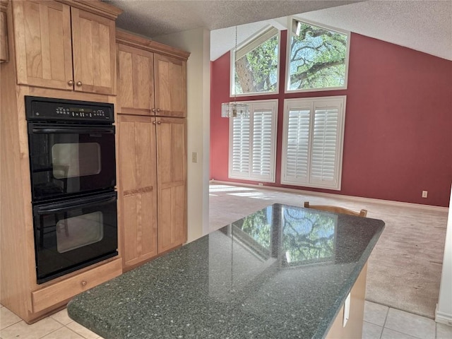 kitchen with dobule oven black, lofted ceiling, a textured ceiling, and light tile patterned floors