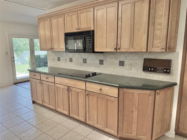 kitchen featuring backsplash, baseboards, light tile patterned floors, and black appliances