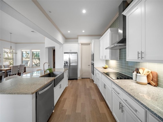 kitchen with light stone countertops, light wood-type flooring, wall chimney exhaust hood, stainless steel appliances, and white cabinetry