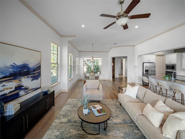 living room featuring ceiling fan, wood-type flooring, and ornamental molding