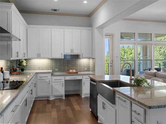 kitchen featuring white cabinets, wall chimney range hood, sink, decorative backsplash, and dark hardwood / wood-style floors