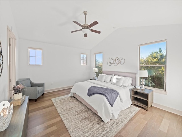 bedroom featuring ceiling fan, multiple windows, and light hardwood / wood-style flooring