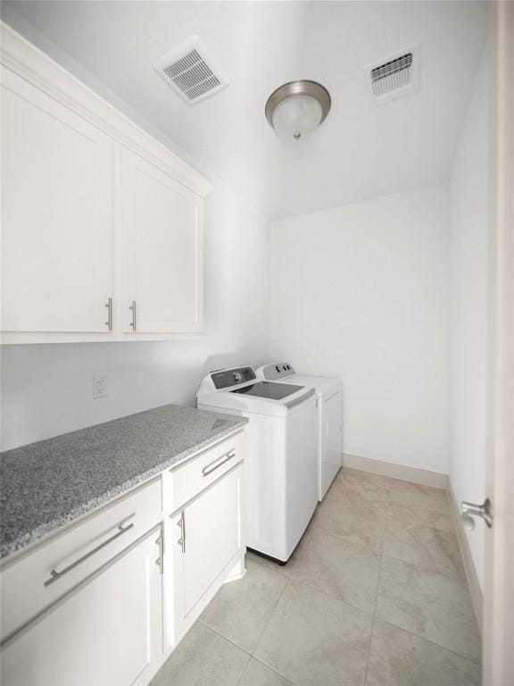 laundry room featuring cabinets, washer and clothes dryer, and light tile patterned flooring