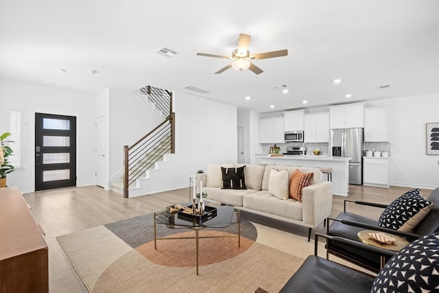 living room with ceiling fan and light hardwood / wood-style floors