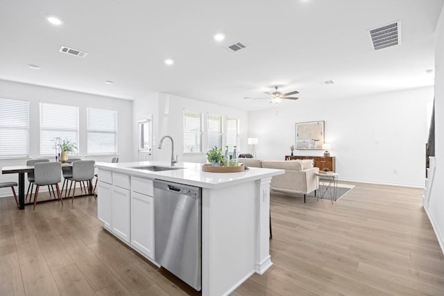 kitchen featuring sink, stainless steel dishwasher, ceiling fan, an island with sink, and white cabinetry