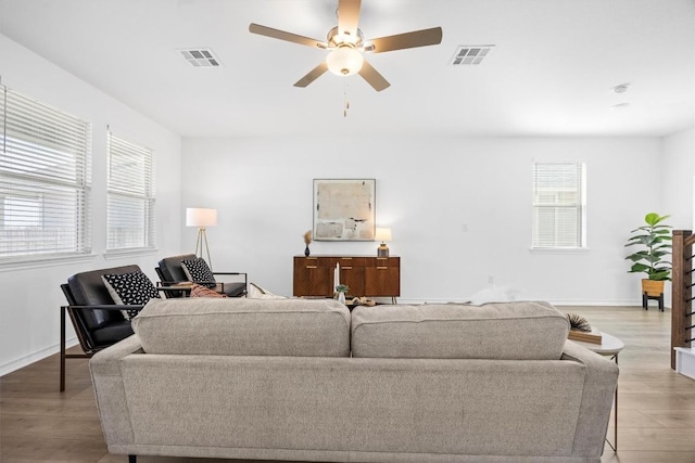 living room with light hardwood / wood-style flooring, a wealth of natural light, and ceiling fan