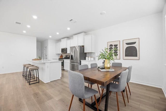 dining space featuring light hardwood / wood-style flooring and sink