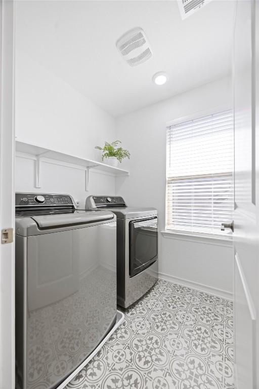 washroom with washer and dryer and light tile patterned flooring