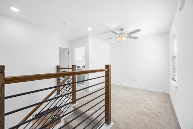 hallway featuring light colored carpet