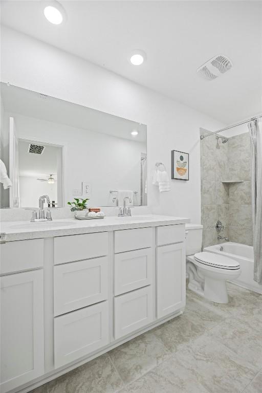 full bathroom with shower / bath combination with curtain, vanity, and toilet