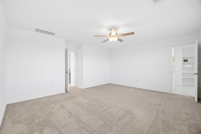 carpeted spare room featuring ceiling fan