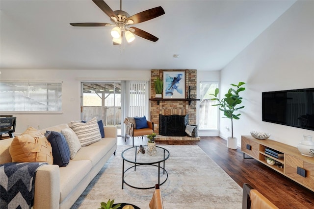 living room with a fireplace, wood-type flooring, and ceiling fan