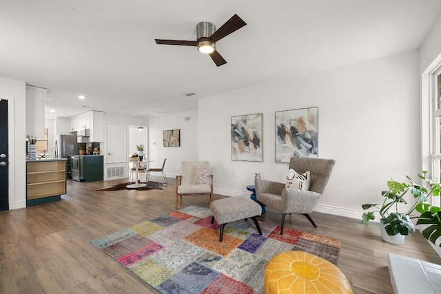 living room with dark hardwood / wood-style flooring and ceiling fan