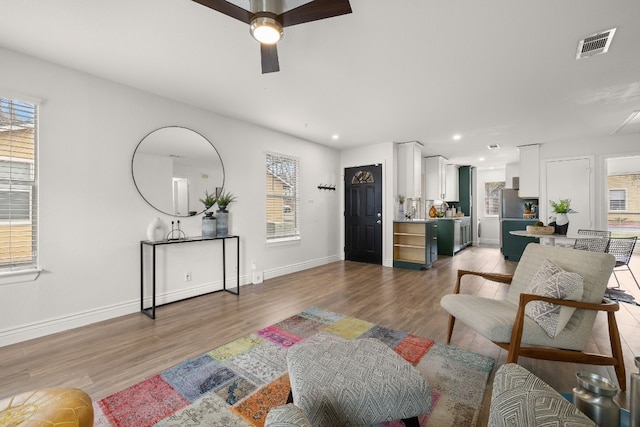 living room featuring hardwood / wood-style floors and ceiling fan