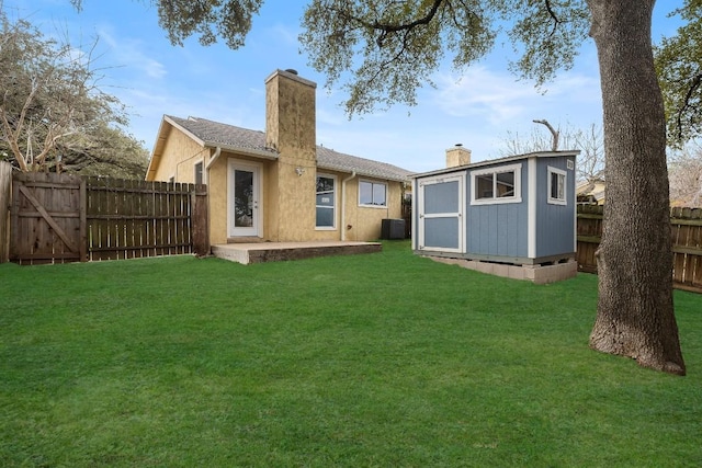 rear view of property with a lawn, a shed, and central air condition unit