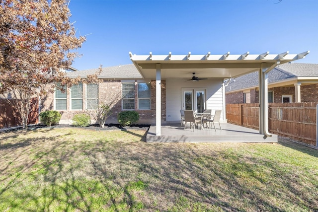 rear view of property featuring a lawn, a patio area, and ceiling fan