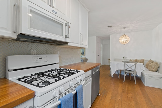 kitchen featuring tasteful backsplash, white appliances, light hardwood / wood-style floors, white cabinetry, and hanging light fixtures