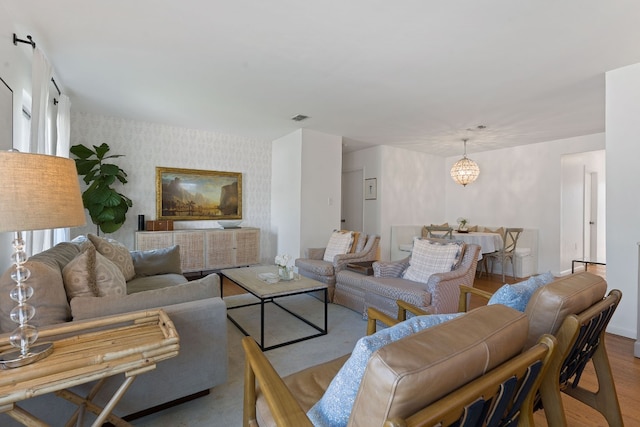 living room featuring light wood-type flooring and an inviting chandelier