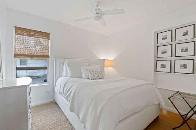 bedroom featuring ceiling fan, crown molding, and light hardwood / wood-style floors