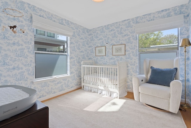 bedroom with a nursery area and multiple windows