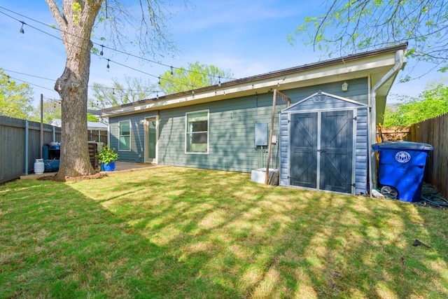 back of house featuring a yard and a storage unit