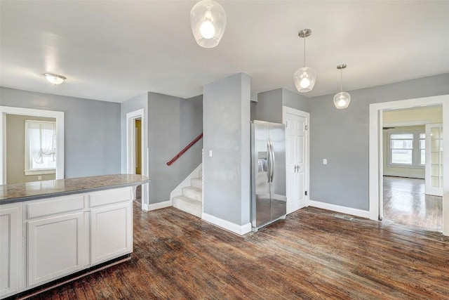 kitchen featuring white cabinets, decorative light fixtures, stainless steel fridge with ice dispenser, and dark wood-type flooring