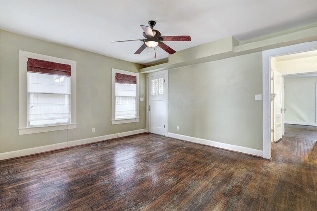 spare room featuring ceiling fan and dark wood-type flooring