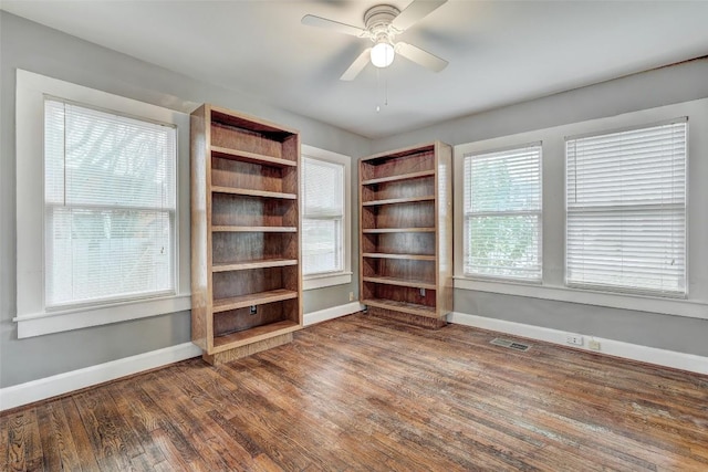 unfurnished living room with ceiling fan, dark hardwood / wood-style flooring, and a wealth of natural light