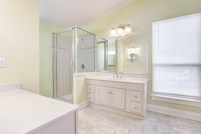 bathroom featuring a shower with door and vanity