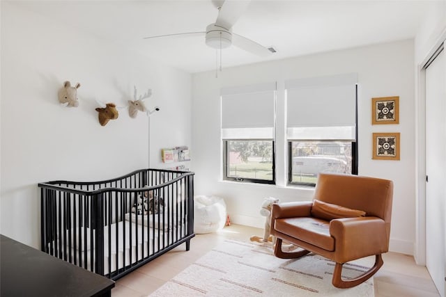 bedroom with a crib, a closet, and ceiling fan