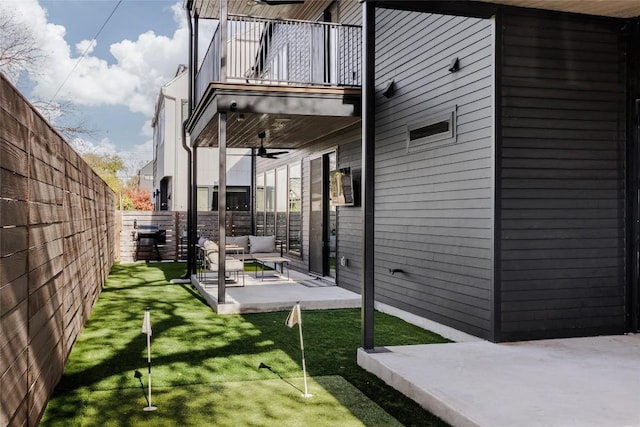 view of yard with ceiling fan, a patio area, a balcony, and an outdoor living space