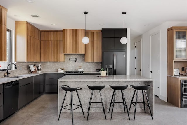 kitchen with stainless steel fridge, sink, black dishwasher, a kitchen island, and hanging light fixtures