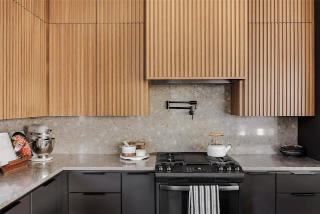 kitchen with decorative backsplash and stainless steel range with gas stovetop