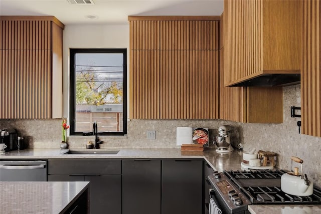 kitchen featuring tasteful backsplash, sink, stainless steel dishwasher, and range